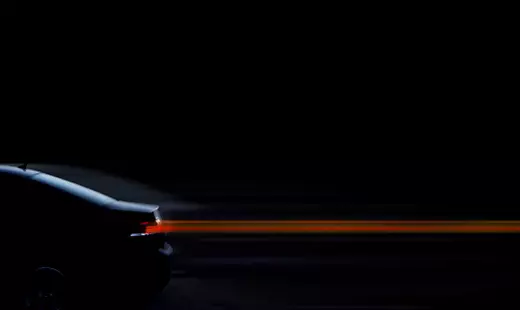 汽車在黑暗中行駛，留下光線軌跡。