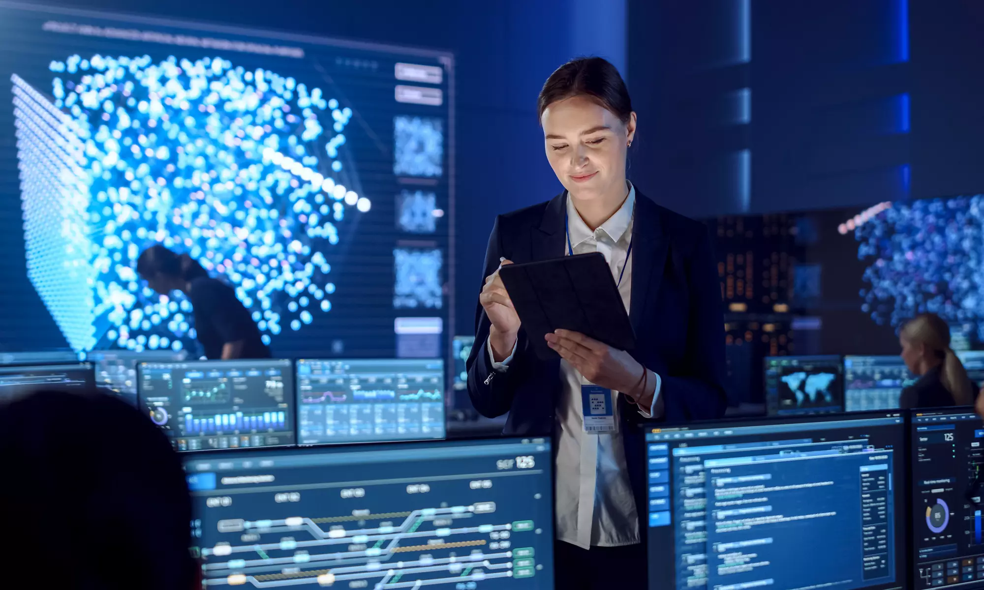 一名女性專案負責人站在平板電腦前檢查工作資料