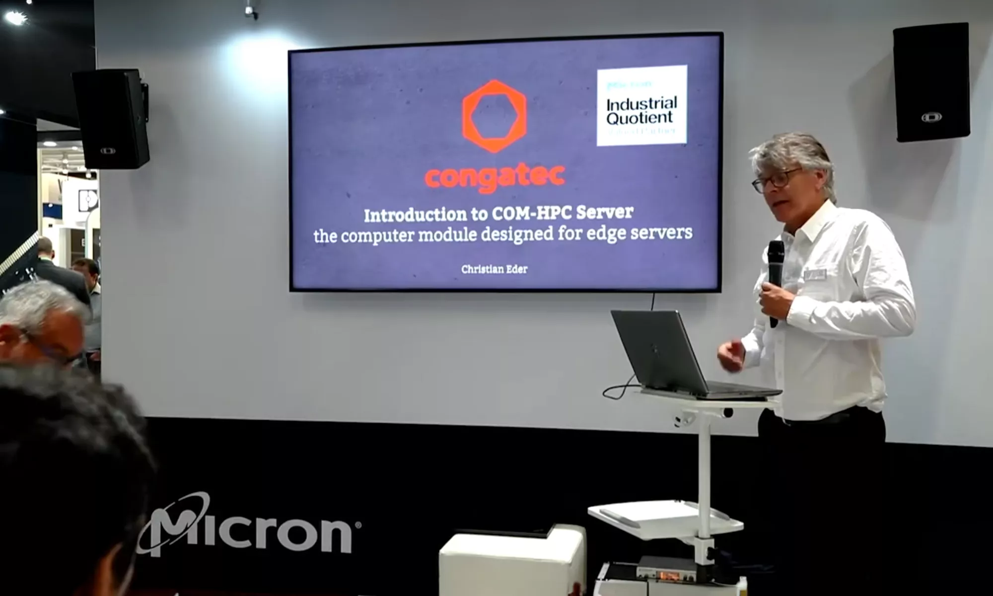 男子在演講，背景螢幕上有 Congatec 標誌